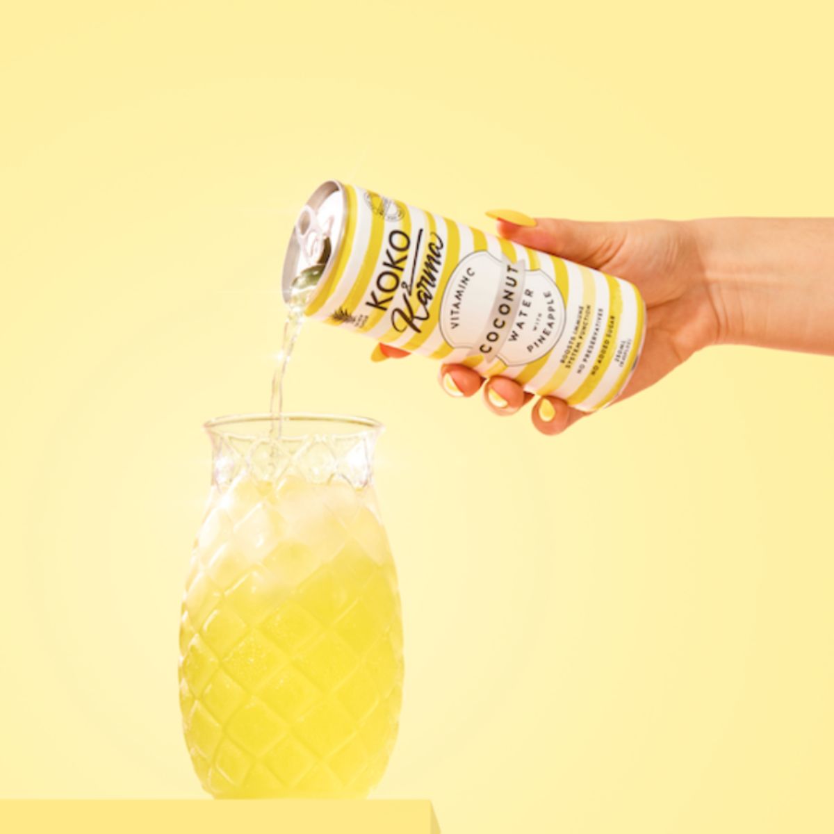 Pouring Koko and Karma Pineapple coconut water into a glass