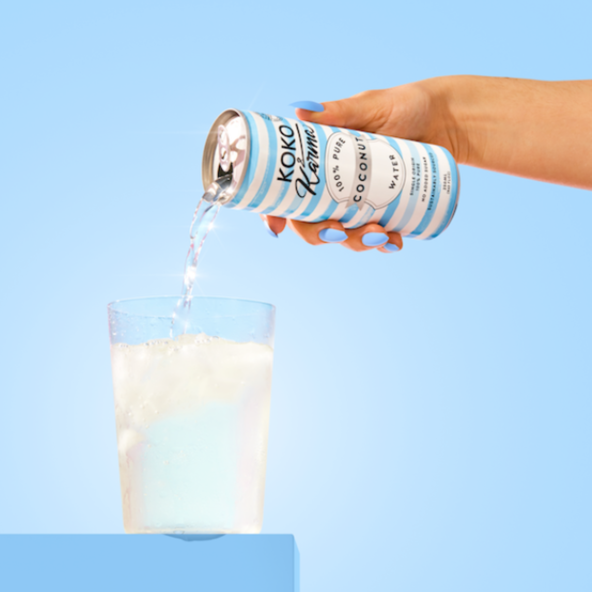 Pouring coconut water from Koko and Karma Pure Coconut can
